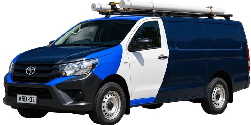 A licensed Chatswood plumbing van loaded with pipe on the roof rack